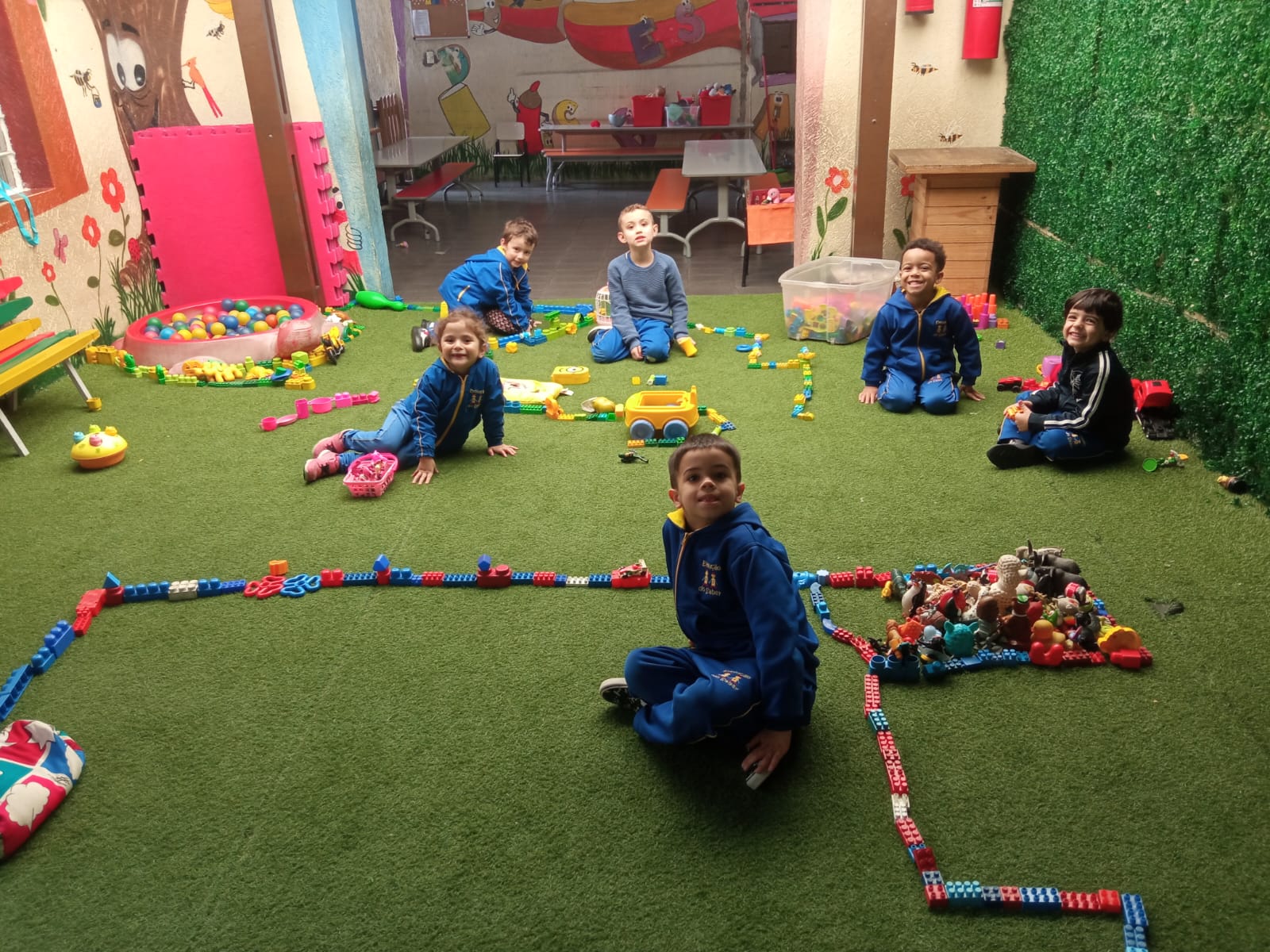 Crianças brincando com blocos de montar na área de recreação