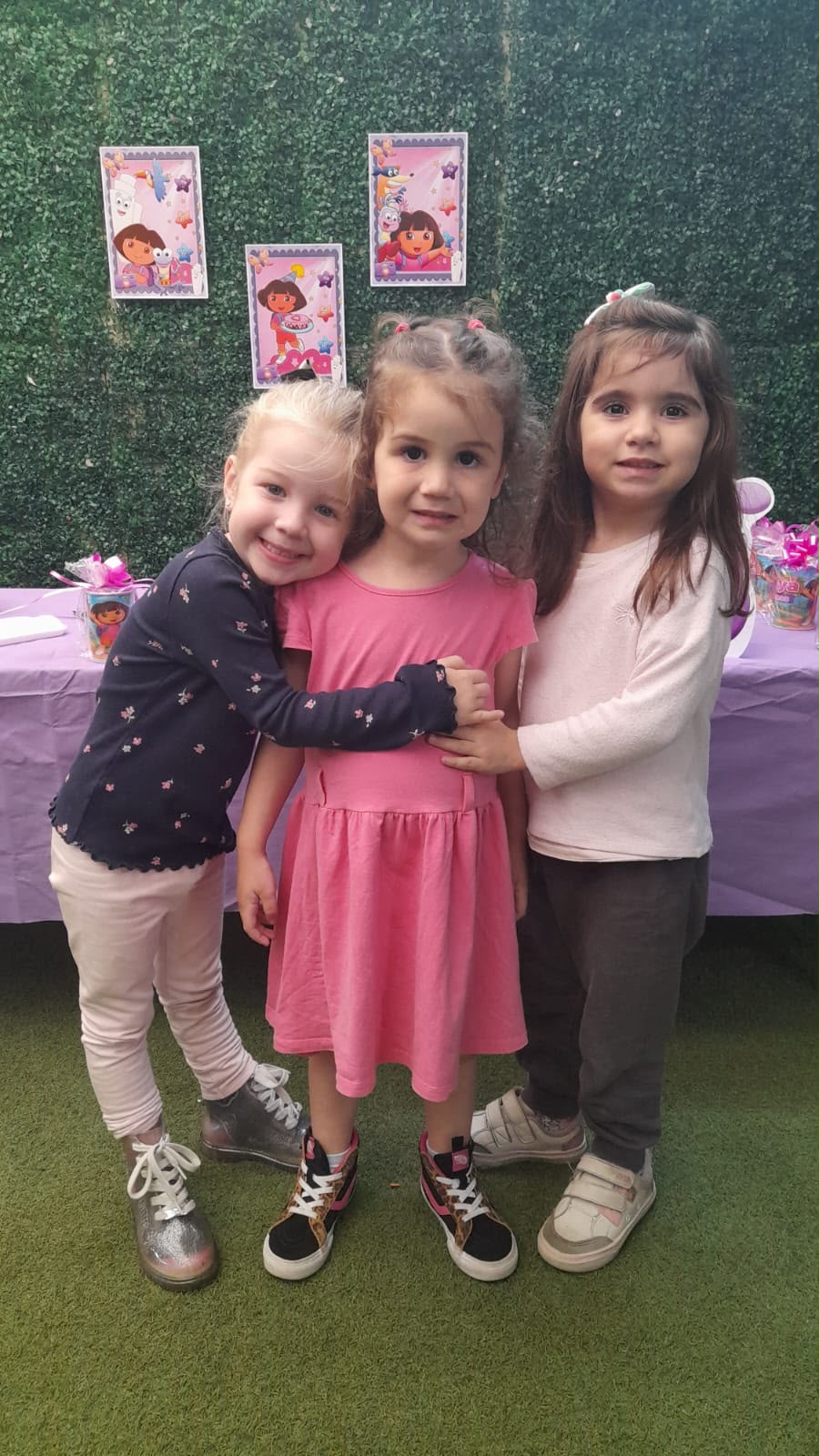 Três amigas se abraçando em festa na escola